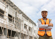© Chanakon - Confident engineer handsome man standing arms crossed at modern home building construction. Architect with white safety helmet at construction site.