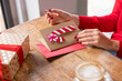 © Westend61 - Woman with Christmas card sitting at table in cafe