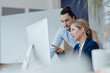 © Westend61 - Businesswoman in meeting with colleague pointing at desktop PC
