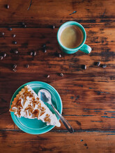 Cake Slice And Coffee With Scattered Roasted Beans On Table