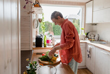Woman With Vegetables In Kitchen At Home
