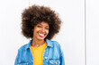© Westend61 - Happy beautiful woman with Afro hairstyle in front of wall
