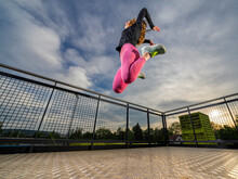 Young Woman Jumping In Sports Park At Sunset