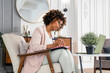 © Westend61 - Woman with diary looking at laptop in office