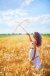 © czamfir - A beautiful woman on a sunny day with an umbrella in a field.