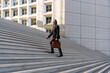 © Westend61 - Mature businessman with bag moving up on staircase