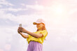 © ximich_natali - A preteen girl takes a selfie on a mobile phone against a blue sky. Horizontal frame, copy space