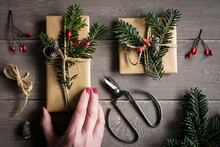 Hand Of Woman Preparing Naturally Wrapped Christmas Presents