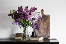 Vase With Freshly Picked Lilacs (Syringa Vulgaris) Standing On Shelf