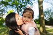 © Westend61 - Mother kissing daughter in park on sunny day