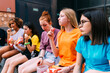 © Westend61 - Girls sitting together eating snacks