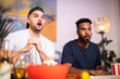 © Westend61 - Surprised man with roommate watching soccer match at home