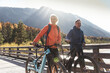 © Westend61 - Austria, Alps, couple with mountain bikes crossing a bridge