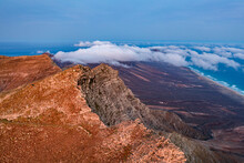 Aerial View Of Volcanic Rocks Of Pico De La Zarza Mountain Peak During A Misty Sunrise, Fuerteventura, Canary Islands, Atlantic