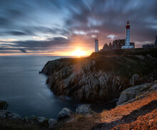 Long Exposure Panorama Of A Sunset With Coloured Clouds At Saint Mathieu Lighthouse, Finistere, Brittany