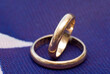 two gold wedding rings on a colored background