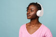 canvas print picture - African american woman smiling and listening to music with headphones