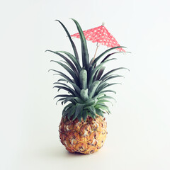 Wall Mural - Image with ripe pineapple with parasol over white background. Summer holidays and tropical theme. vintage filtered