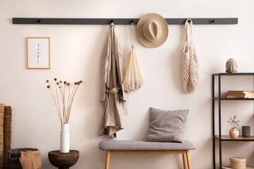 the stylish composition of cosy entryway with grey bench, coffee table, hanger and personal accessor