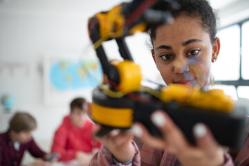 Wall Mural - college student holding her robotic toy at robotics classroom at school.