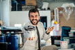 © Dusan Petkovic - A smiling manager showing black printing color in bucket to a camera.