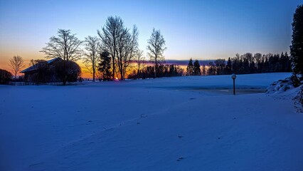 Wall Mural - Snow-Covered Landscape At Winter Countryside Illuminated With Sunset Sky. Timelapse