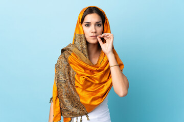 Sticker - Young Moroccan woman with traditional costume isolated on blue background showing a sign of silence gesture