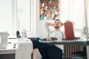 Wall Mural - Jolly fashion designer enjoying break in own office