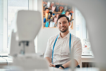 Wall Mural - Happy male tailor having break at work in own atelier