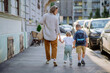 © Halfpoint - Young mother with zero waste shopping bag holding hands with her children and walking in city street street