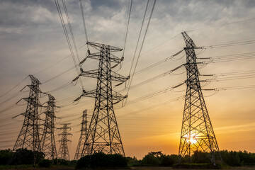 High voltage electric tower at sunset. Transmission power line. Electricity pylons and sky clouds background.