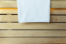 Clean And Fresh White Towel Hanging On Wooden Boards In The Sauna