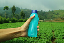 Holding A Tumbler Of Natural Fresh Water Mountains In The Morning Green Garden Background