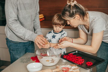 Baking process of young family, people have fun in kitchen at home. Father, mother and child cooking together, little boy 4-5 years old,