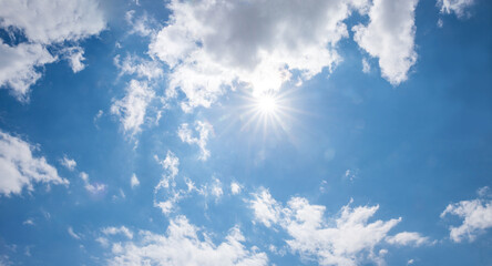 Wall Mural - panorama cloud scape background with bright sun and fluffy white cumulus on blue sky