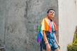 © anderson - gay teen man with lgbt flag on gray city wall in sunny day