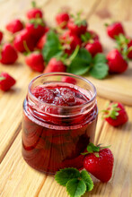 Strawberry Jam In Glass Jar On Wooden Board With Fresh Strawberry Fruit And Green Leaves On Wooden Background. Recipe Of Delicious Homemade Berry Jam Of Strawberry Full Of Vitamins And Antioxidants.