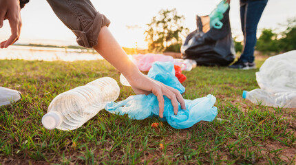 Wall Mural - woman hand picking up garbage plastic bottle for cleaning at park