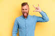 © Asier - Young caucasian man isolated on yellow background showing rock gesture with fingers