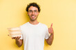 © Asier - Young caucasian man holding tupper isolated on yellow background smiling and raising thumb up