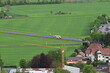Krankenwagen und Autos fahren über eine Landstraße mit grünen Feldern bei Hammelburg, Bad Kissingen, Franken, Bayern, Deutschland