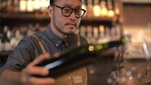 Slow Motion Shot, Male Bartender Pouring Wine Into Glasses At Counter.