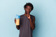 © Asier - Young african american man holding protein milkshake isolated on blue background looking sideways with doubtful and skeptical expression.