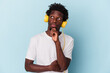 © Asier - Young african american man listening to music isolated on blue background looking sideways with doubtful and skeptical expression.
