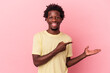© Asier - Young african american man isolated on pink background excited holding a copy space on palm.