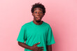 © Asier - Young african american man isolated on pink background touches tummy, smiles gently, eating and satisfaction concept.