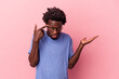 © Asier - Young african american man isolated on pink background showing a disappointment gesture with forefinger.