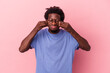 © Asier - Young african american man isolated on pink background doubting between two options.