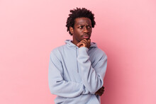 Young African American Man Isolated On Pink Background Relaxed Thinking About Something Looking At A Copy Space.