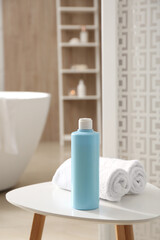 Wall Mural - Bottle of shower gel and fresh towels on white table in bathroom